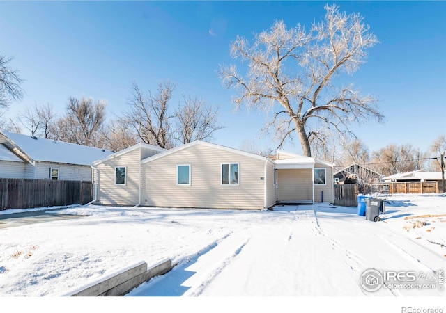 view of snow covered back of property