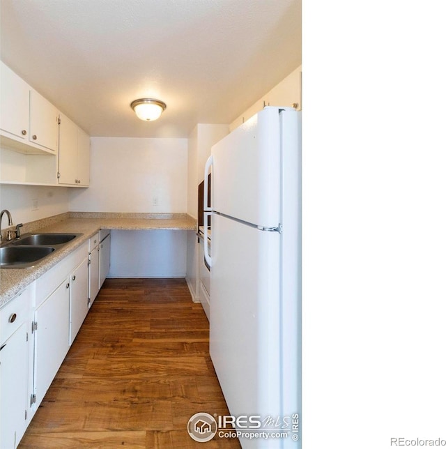 kitchen with sink, white refrigerator, white cabinetry, and dark hardwood / wood-style flooring