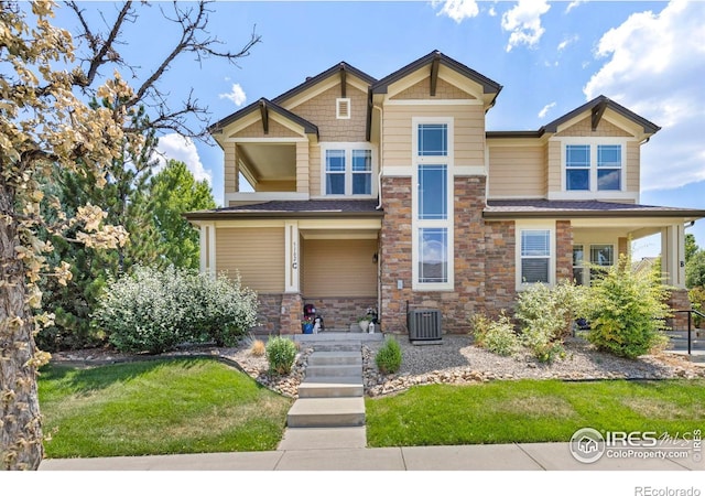 craftsman inspired home featuring a front yard, covered porch, and central AC unit