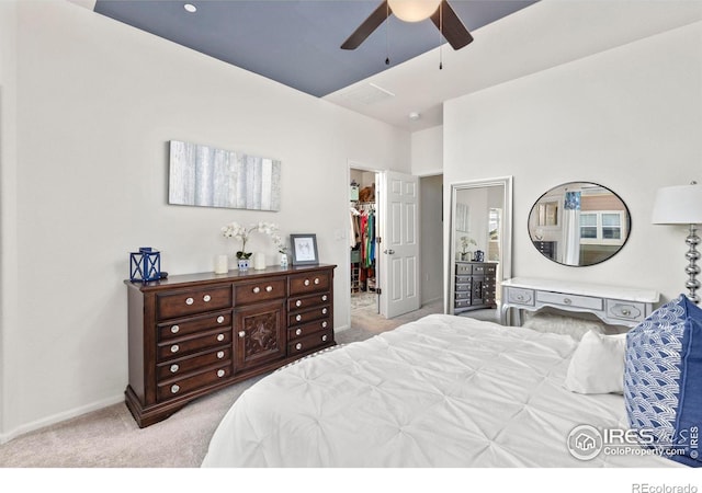 carpeted bedroom with a closet, ceiling fan, and a spacious closet