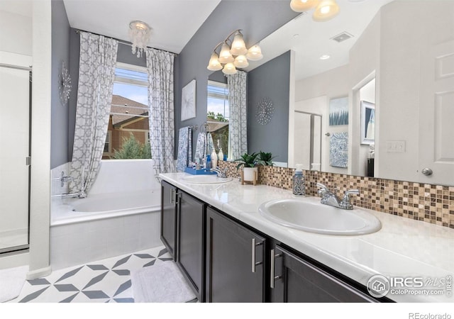 bathroom featuring shower with separate bathtub, vanity, and an inviting chandelier