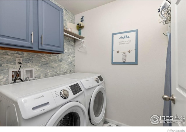 washroom featuring cabinets and washer and clothes dryer