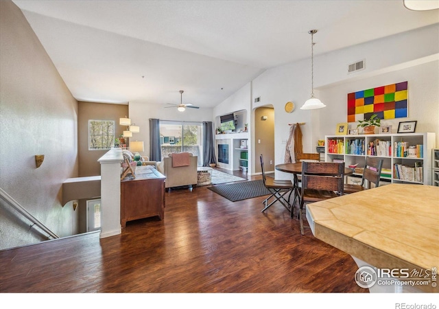 living room with ceiling fan, vaulted ceiling, and dark hardwood / wood-style floors