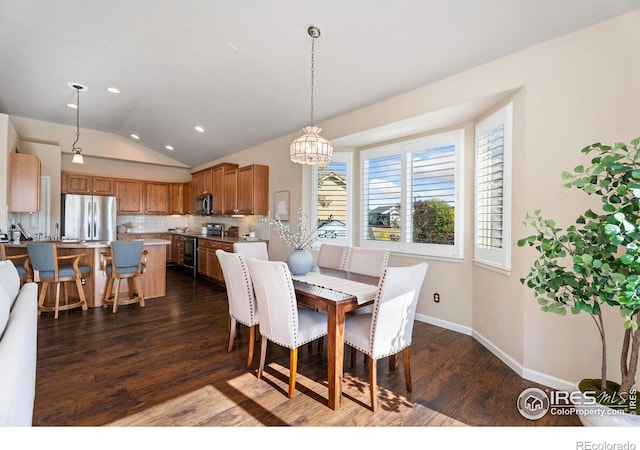 dining space with vaulted ceiling, a notable chandelier, and dark hardwood / wood-style floors