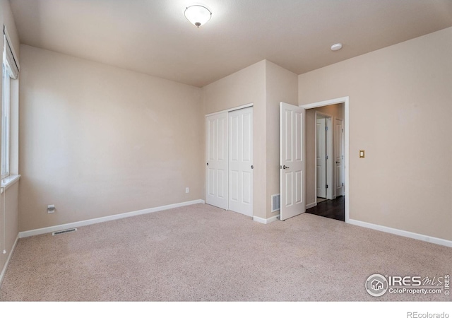 unfurnished bedroom featuring a closet and carpet flooring