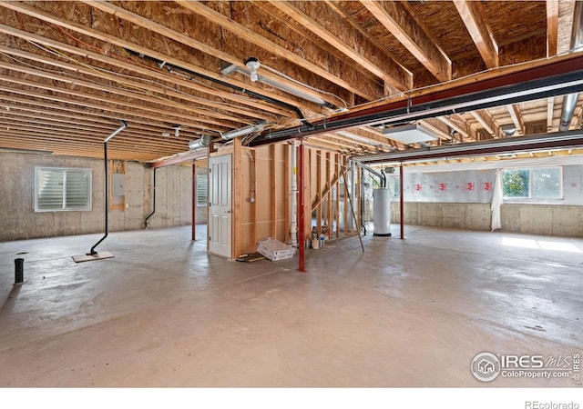 basement featuring electric panel and gas water heater