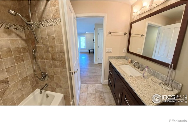 bathroom with tiled shower / bath and vanity