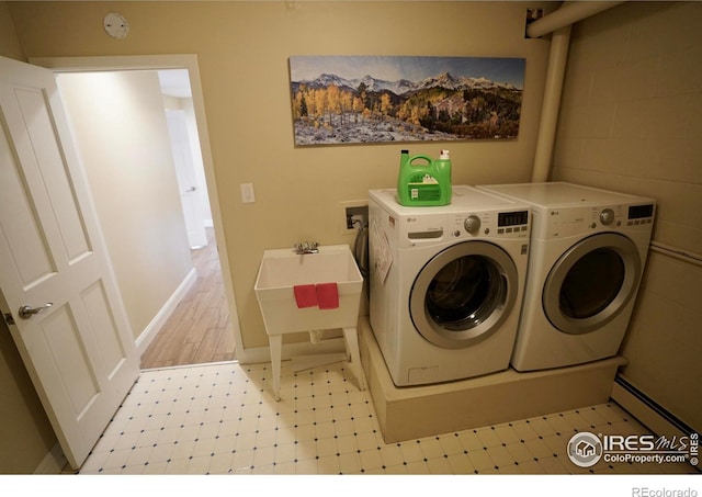 laundry area with separate washer and dryer and sink