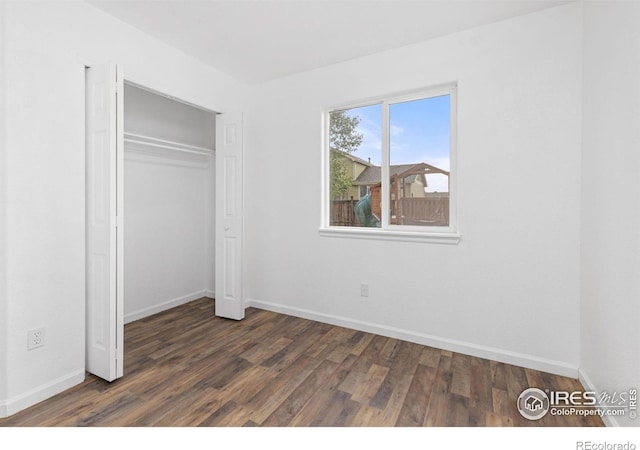 unfurnished bedroom with a closet and dark wood-type flooring