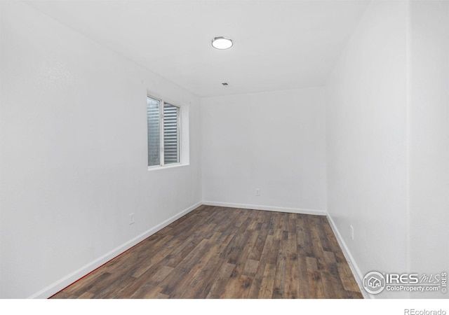 empty room with dark hardwood / wood-style flooring