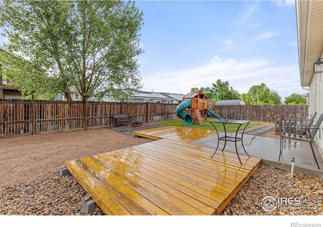 wooden deck featuring a playground