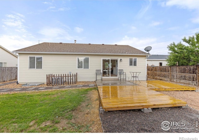 rear view of house with a deck and a yard