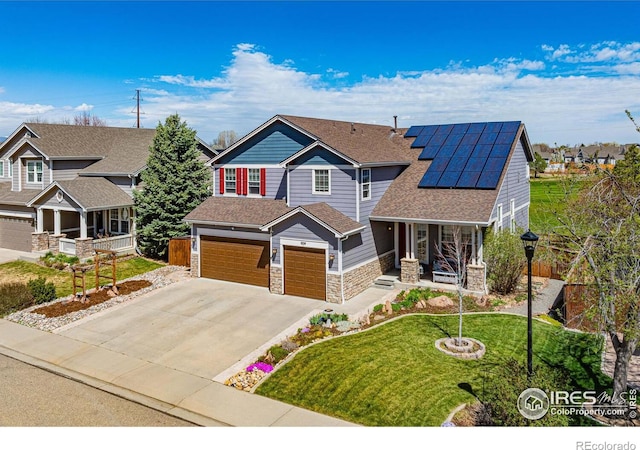 craftsman-style home featuring a garage, solar panels, covered porch, and a front yard