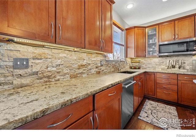 kitchen with dark hardwood / wood-style floors, decorative backsplash, sink, light stone countertops, and stainless steel appliances