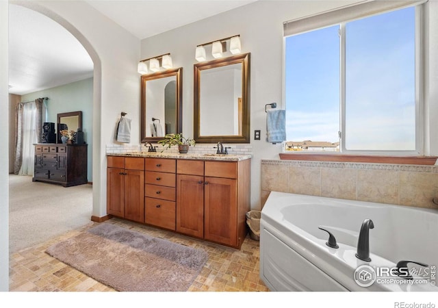 bathroom with a washtub and vanity