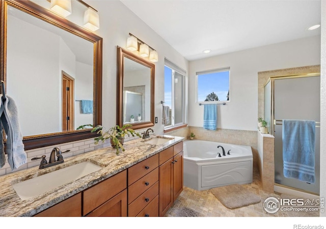 bathroom featuring backsplash, vanity, and independent shower and bath