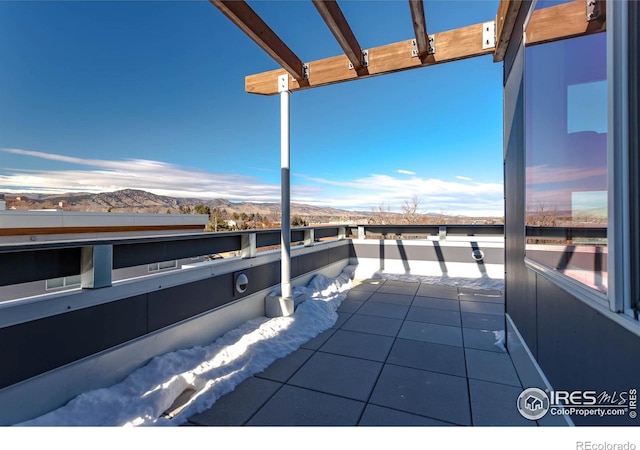 view of patio featuring a mountain view and a balcony