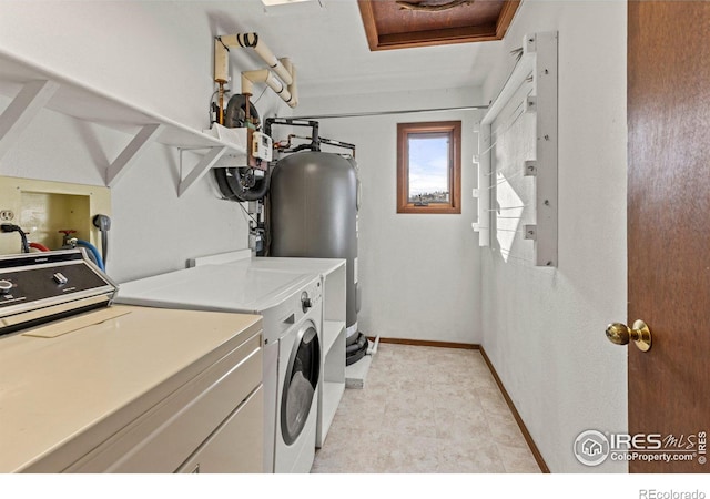 laundry area featuring washing machine and dryer and water heater