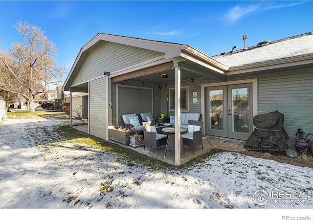 snow covered house with french doors and a patio area