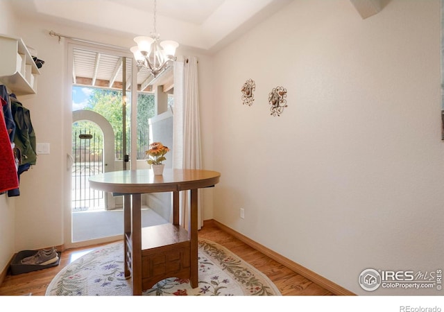 dining area with wood-type flooring and an inviting chandelier