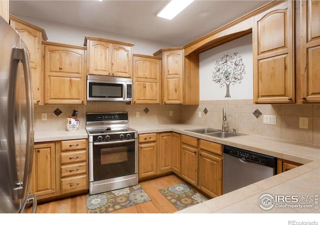 kitchen with decorative backsplash, appliances with stainless steel finishes, and sink