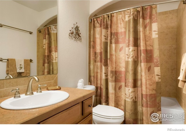 full bathroom featuring toilet, vanity, and shower / tub combo with curtain