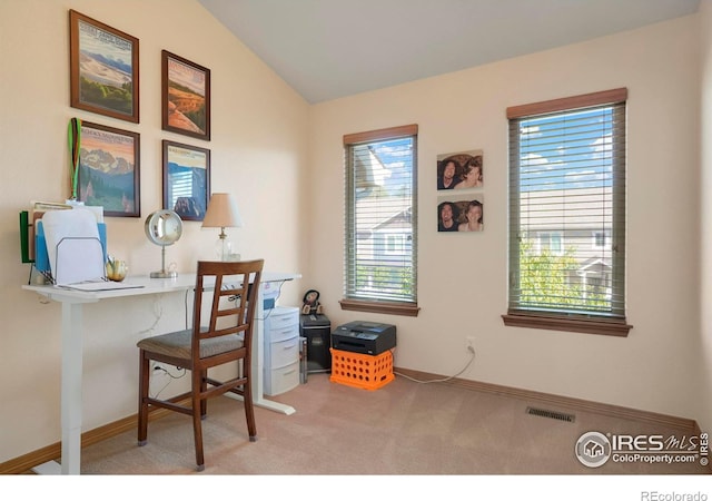 office space featuring a healthy amount of sunlight, lofted ceiling, and carpet floors