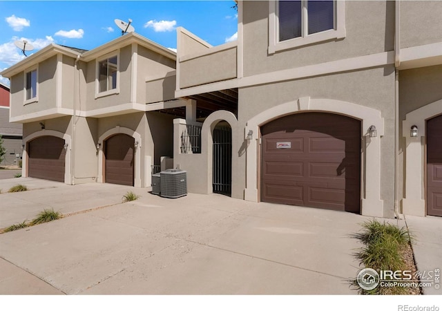 view of front of home with central AC unit and a garage