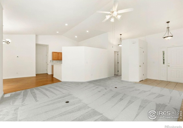 unfurnished living room with ceiling fan, high vaulted ceiling, and light carpet