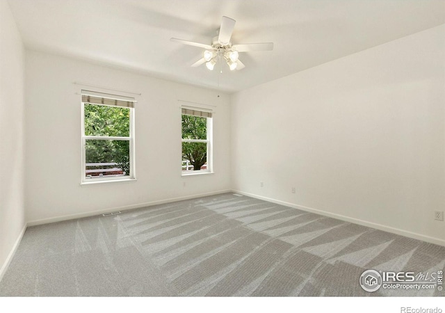 carpeted spare room featuring ceiling fan