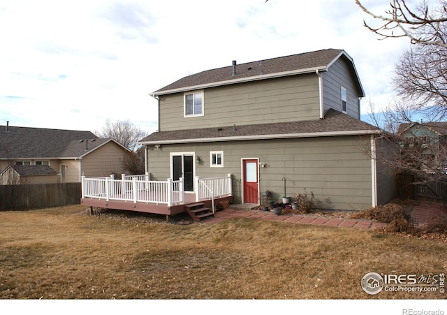 back of property with a yard and a wooden deck