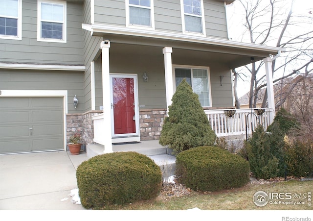 entrance to property featuring a garage and a porch