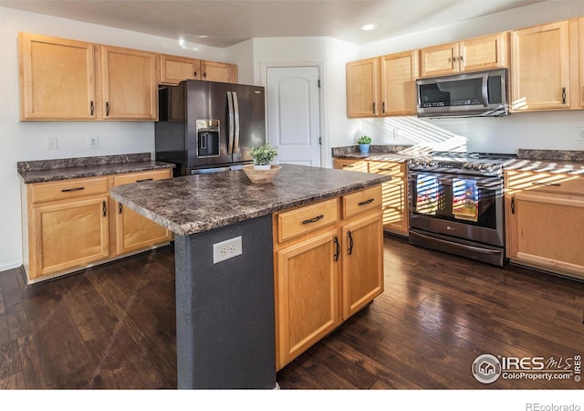 kitchen featuring appliances with stainless steel finishes, dark hardwood / wood-style flooring, and a kitchen island