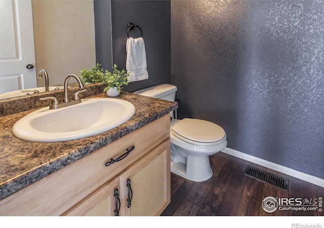 bathroom featuring hardwood / wood-style floors, toilet, and vanity