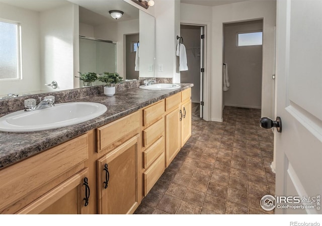 bathroom featuring a wealth of natural light, an enclosed shower, and vanity