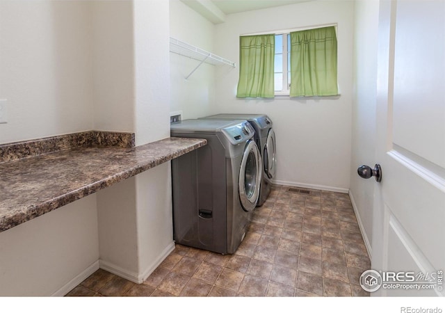 clothes washing area with washing machine and dryer