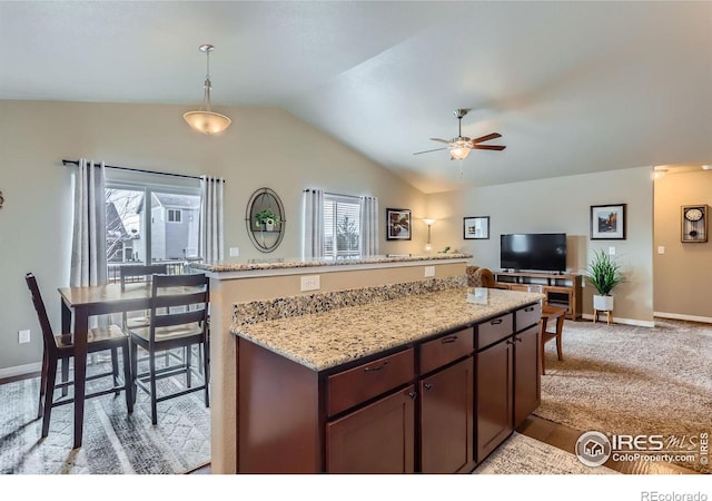 kitchen featuring vaulted ceiling, hanging light fixtures, light colored carpet, dark brown cabinetry, and ceiling fan