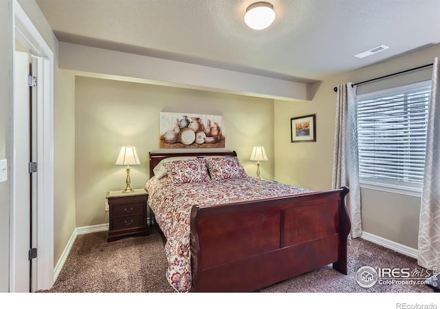 bedroom with carpet floors and a textured ceiling