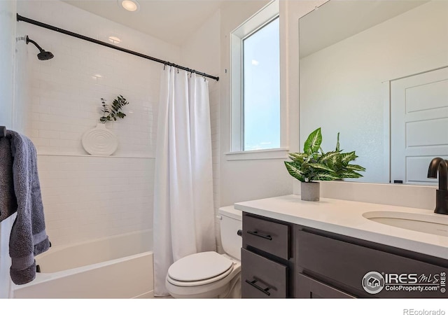 full bathroom with vanity, shower / tub combo with curtain, and toilet