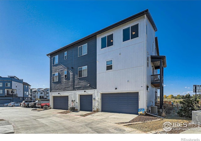 back of property with a garage and cooling unit