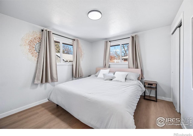 bedroom with a closet and light hardwood / wood-style flooring