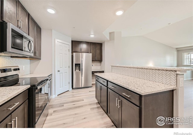 kitchen with tasteful backsplash, lofted ceiling, light hardwood / wood-style floors, dark brown cabinetry, and stainless steel appliances