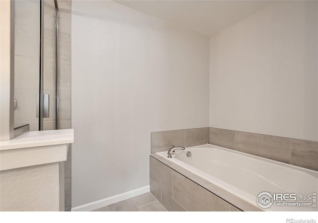 bathroom featuring tile patterned flooring and tiled tub