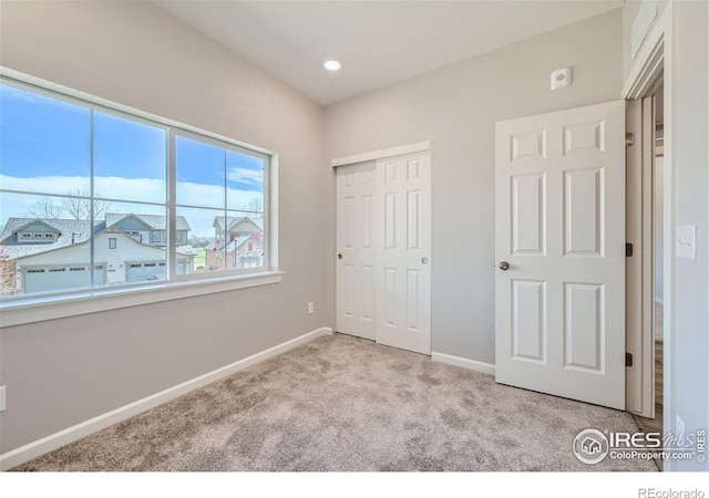 unfurnished bedroom featuring a closet and light colored carpet