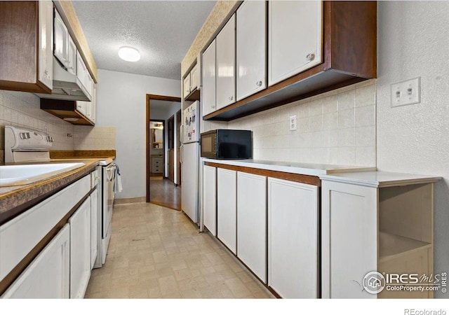 kitchen featuring decorative backsplash, sink, white appliances, a textured ceiling, and white cabinets