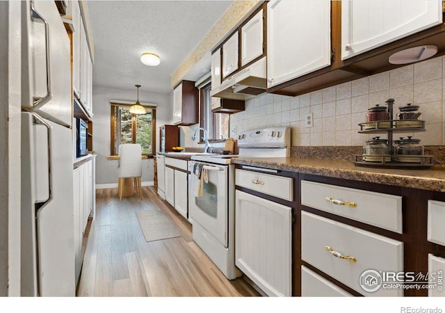 kitchen featuring white cabinetry, white appliances, hanging light fixtures, a textured ceiling, and sink