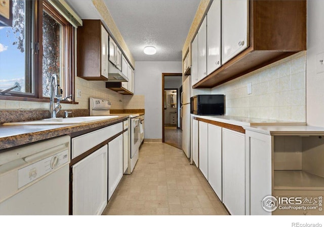 kitchen featuring white cabinetry, sink, and white appliances