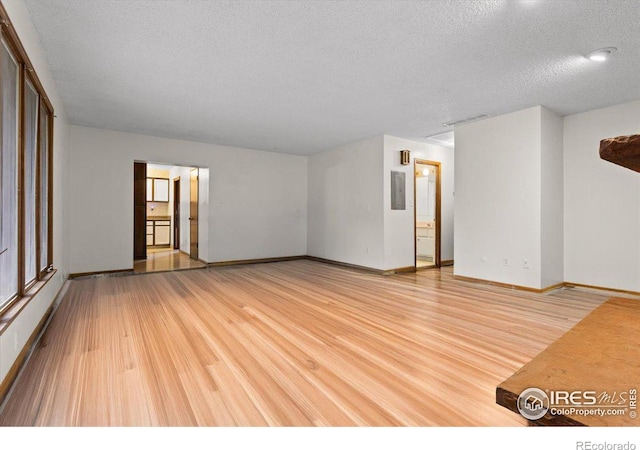 spare room featuring light hardwood / wood-style floors and a textured ceiling