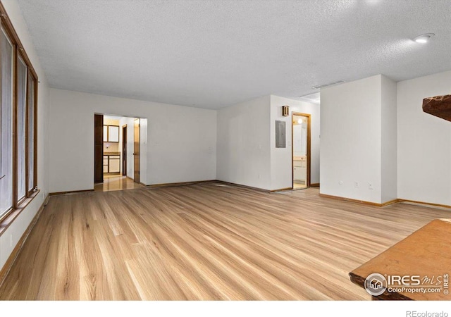 unfurnished room featuring a textured ceiling and light hardwood / wood-style floors