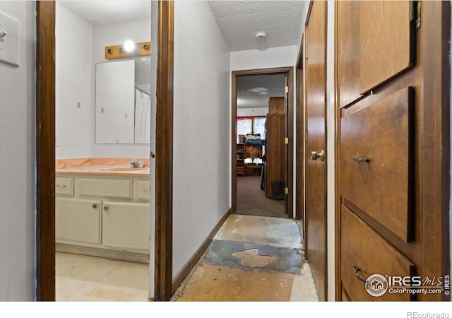 hall featuring sink and a textured ceiling